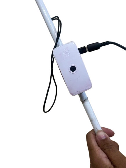 Drishti AI talking cane: sensor unit on a white cane, held in hand
